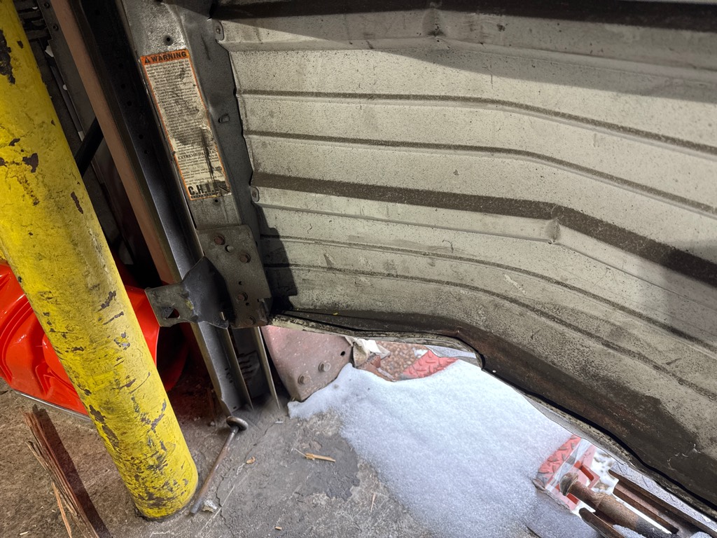 Garage panel repair for a dented residential garage door with multiple damaged panels.