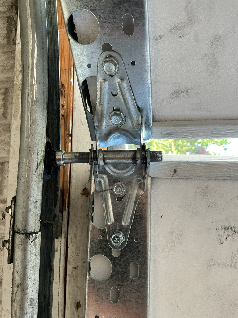  Residential garage door track repair showing track damage and hardware alignment.