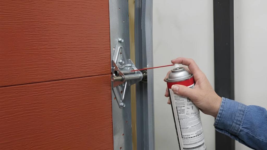 Technician applying lubricant to garage door hardware to help reduce noise from a noisy garage door.