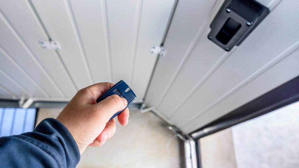 Homeowner using a garage door remote to test the operation of a sectional garage door