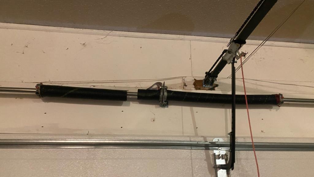 Broken garage door torsion spring above a sectional garage door